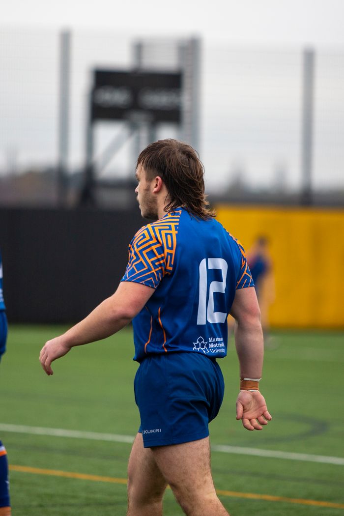 Action shot of a rugby player during a university sports match on field.